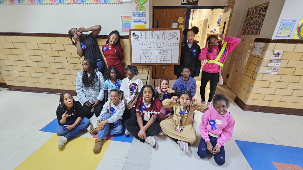 Photo club members stand outside their exhibit.