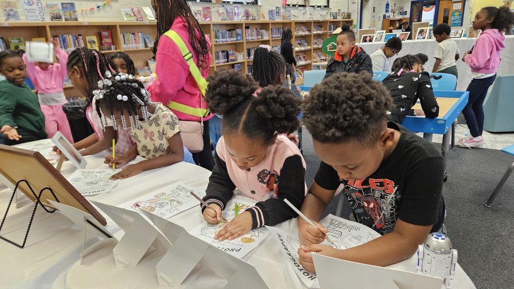 Students practice "I Spy" at a table as they browse pictures.
