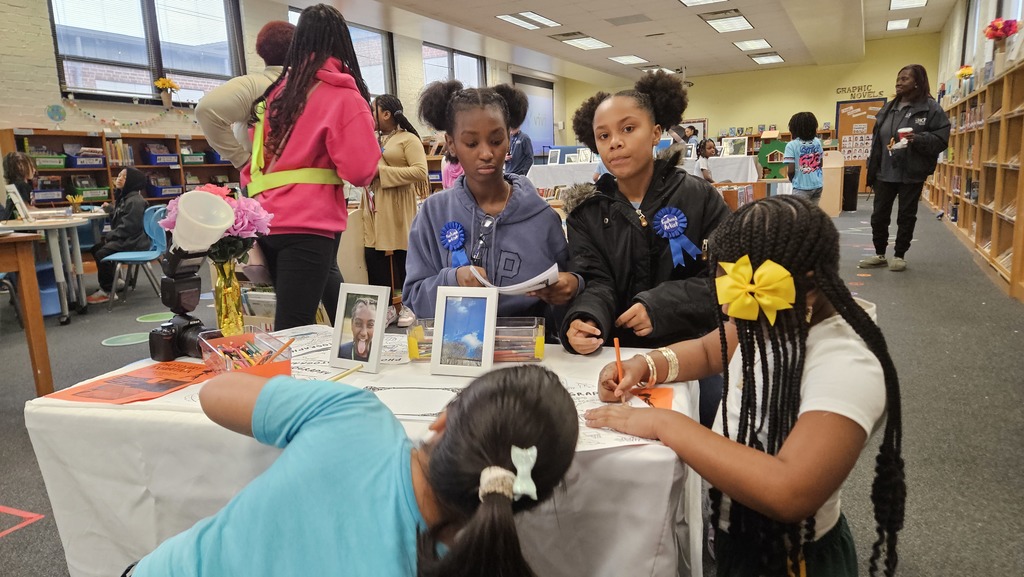 Students host others at a table exhibit.