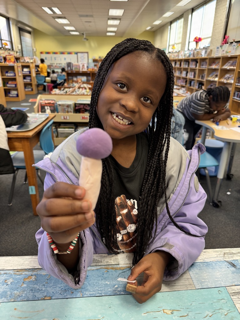 Student shows off a microphone that she made.