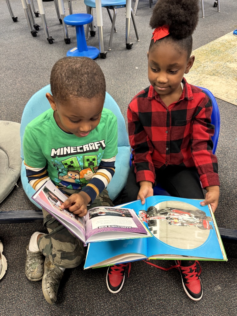 Two students look at books together.