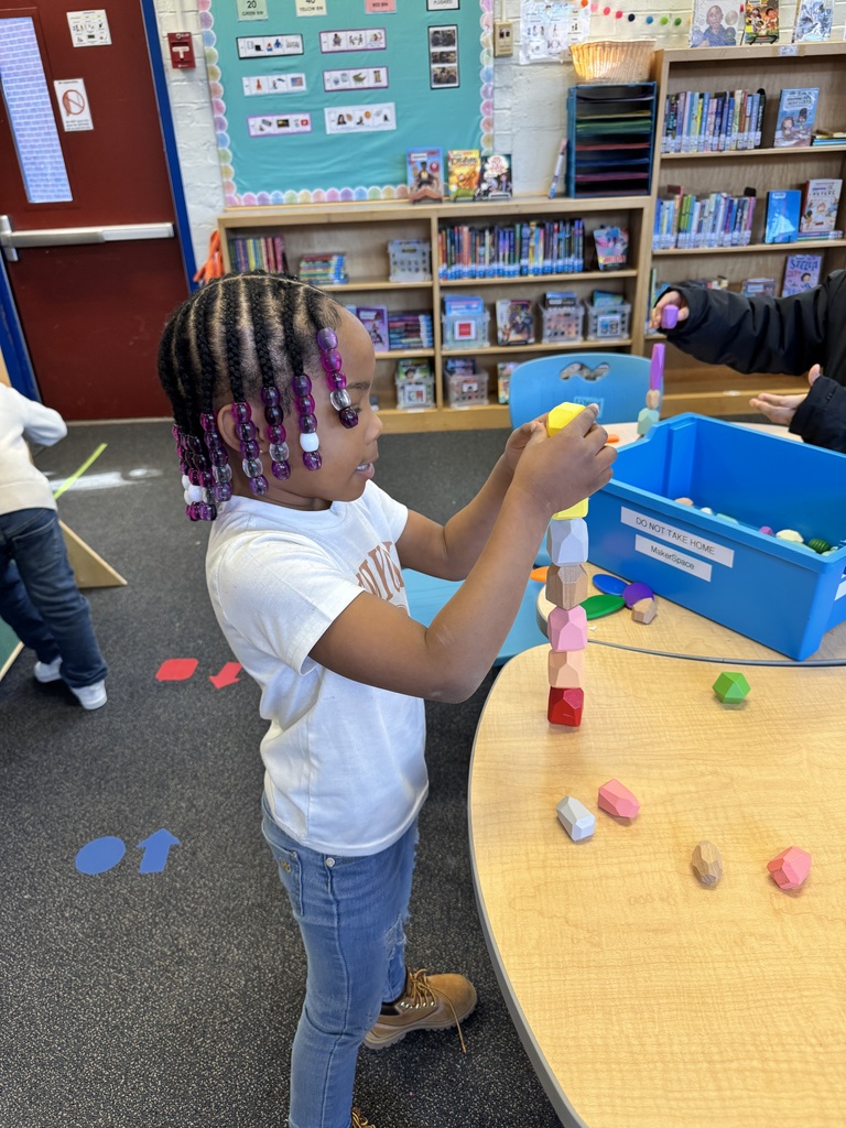 Student stacks rocks in a challenge.