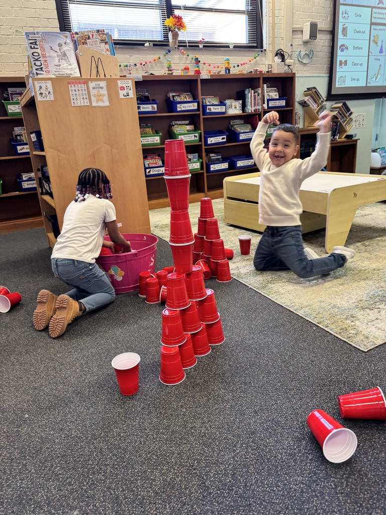 Students build together excitedly with red cups.