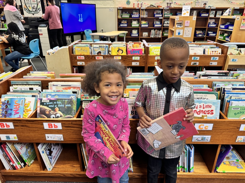 Student shows off their shirt with a friend.