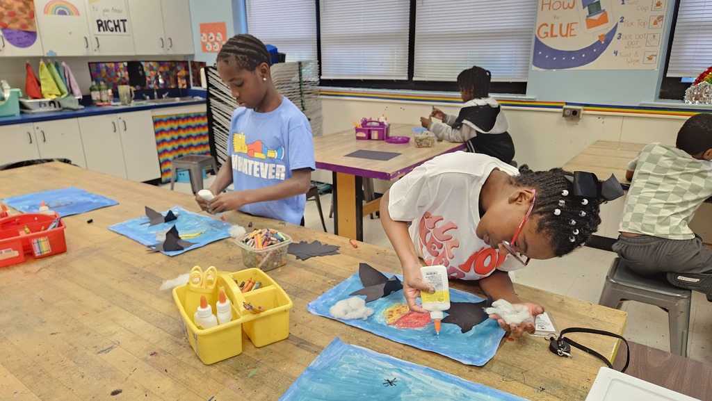 4th grade students glue different components of their art together.