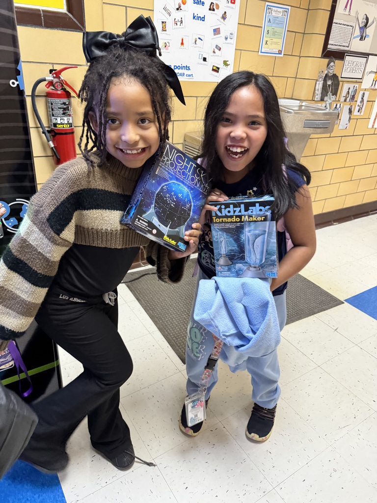 Students hold up their prizes to showcase them for the screen.