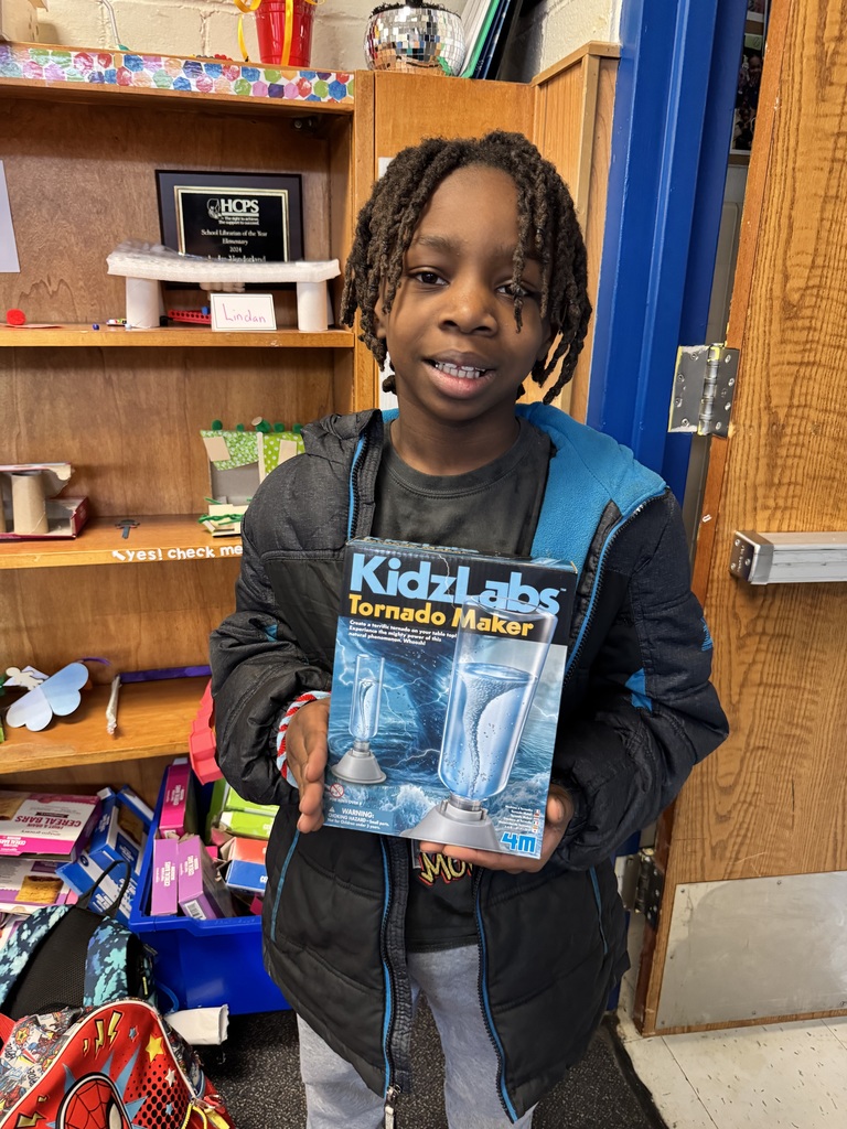Student holds up his prize to showcase for the screen.