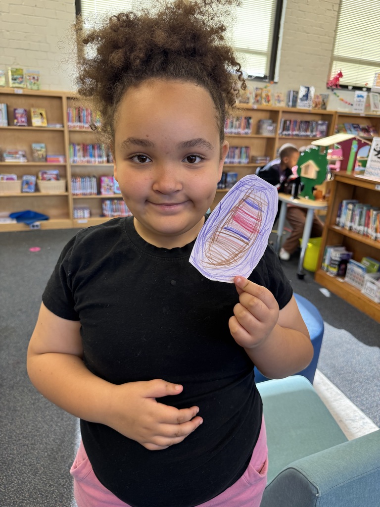 Student holds up a small portal that she created.