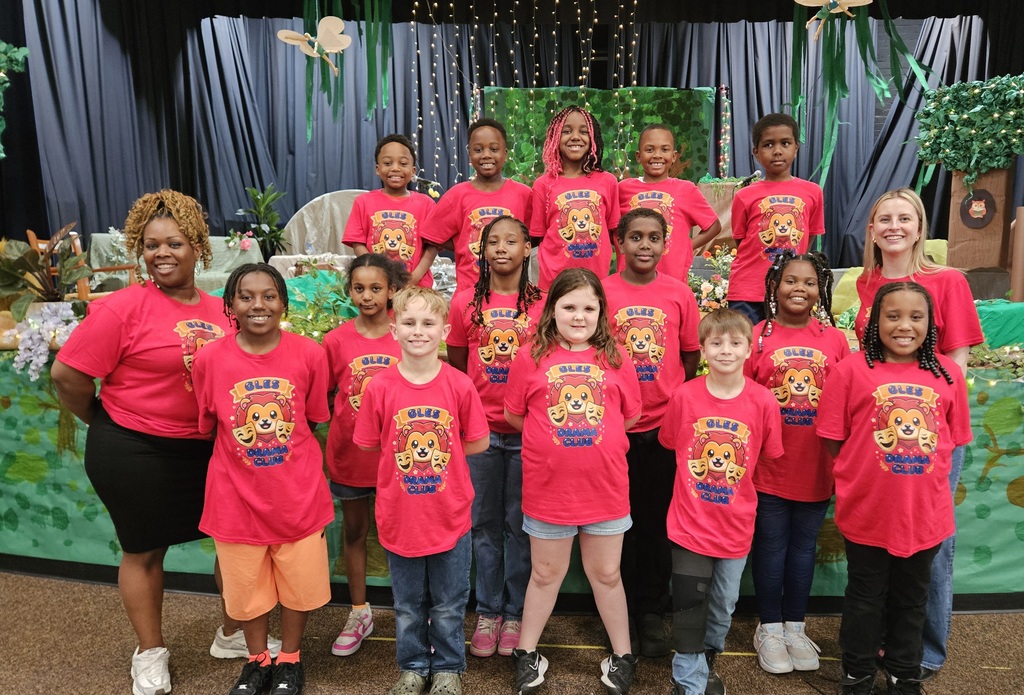 Drama club is standing together with their red Drama Club shirts.
