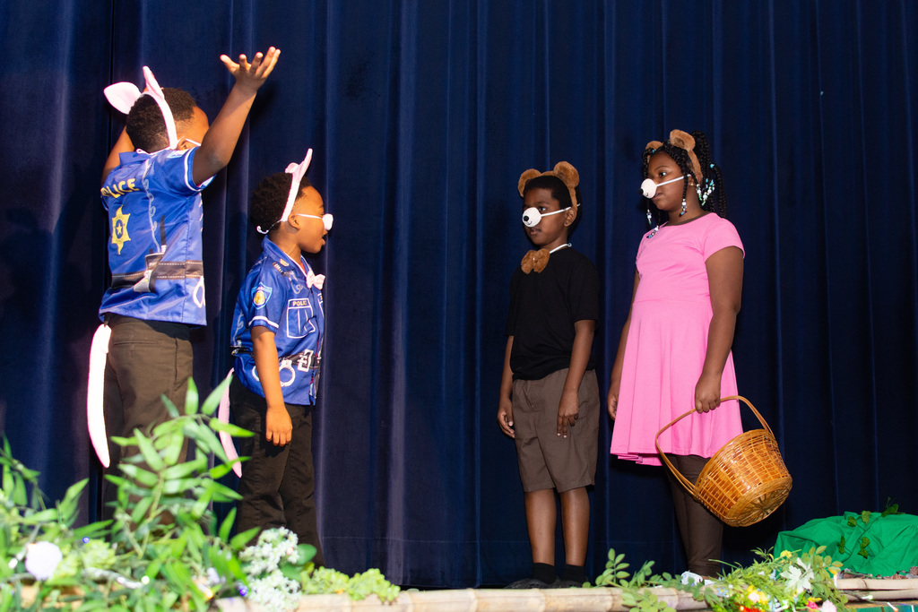 Two students in police costumes greet two students dressed as bears.