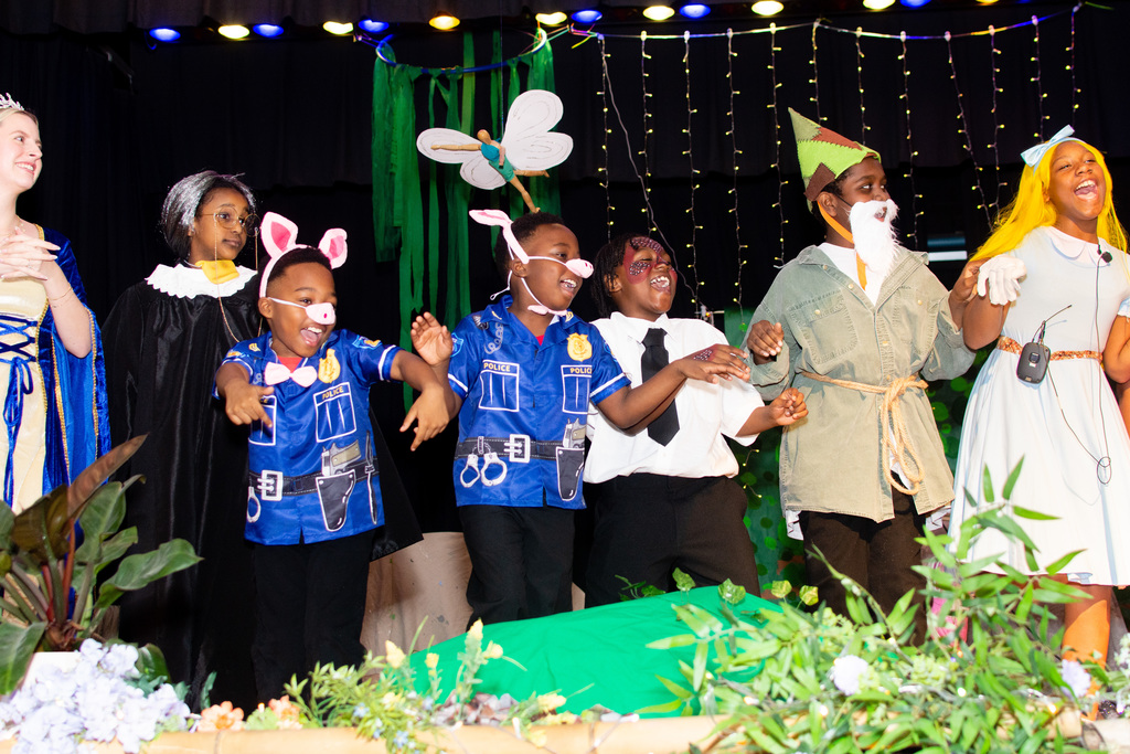 Students sing on stage at the end of the show.