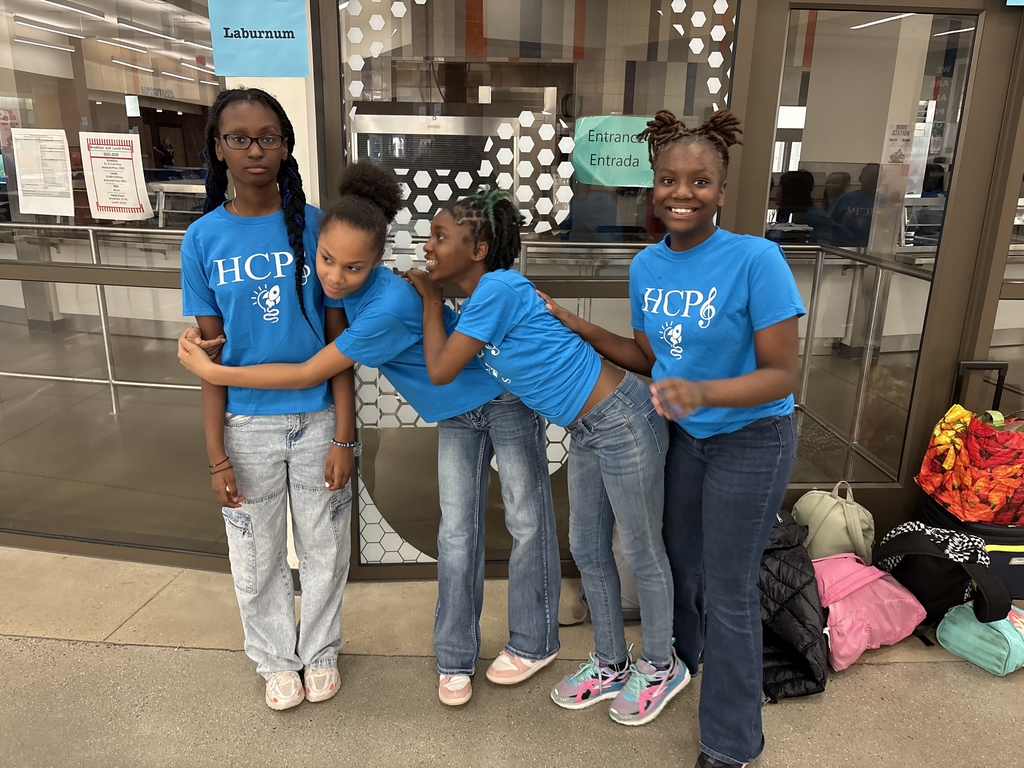 Four students stand in a hug together.