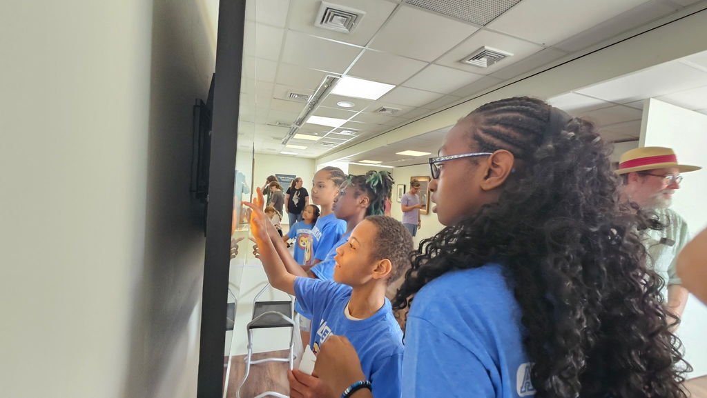Students look at art on the board.