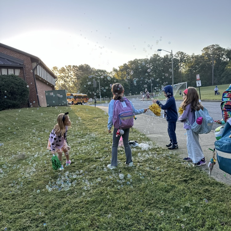 kids playing with bubbles by the bus loop