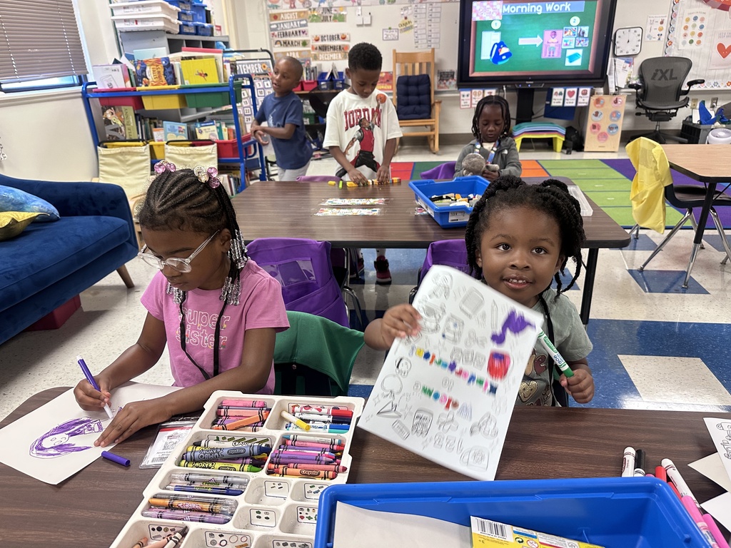 Two students work at their tablescoloring worksheets.