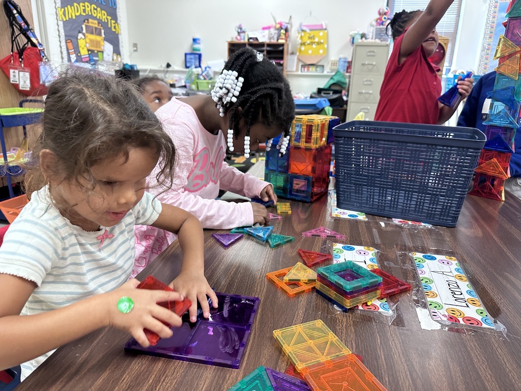 Two students build with magnatiles at their table.