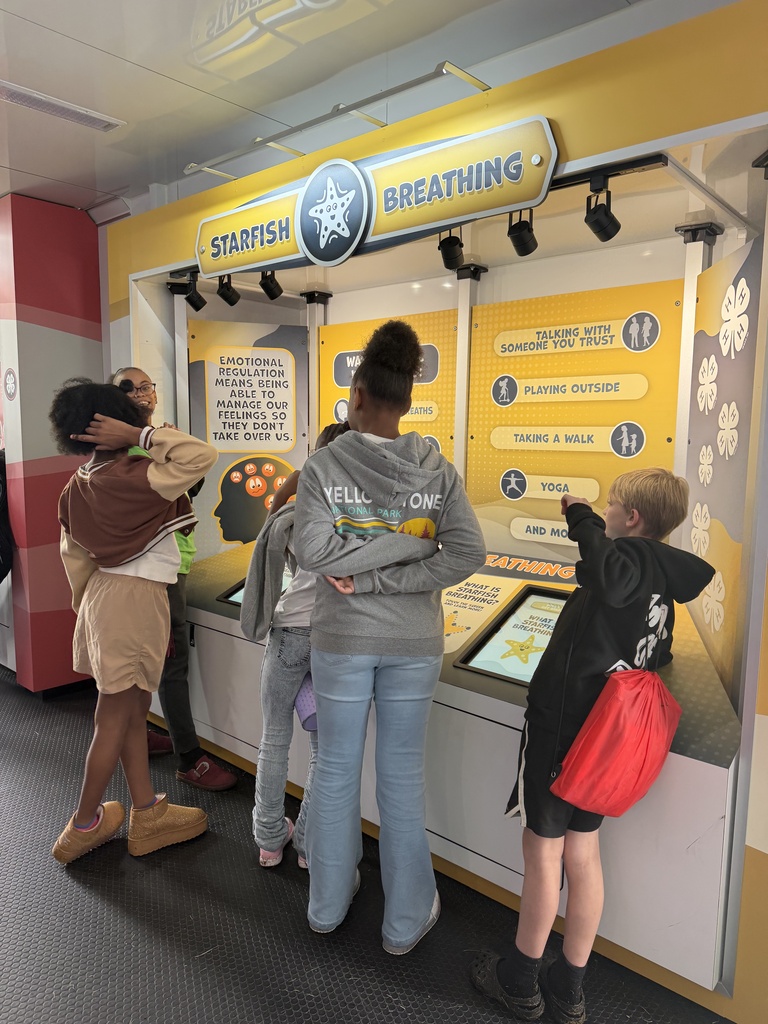 Five students stand infront of a science exhibit on starfish breathing.