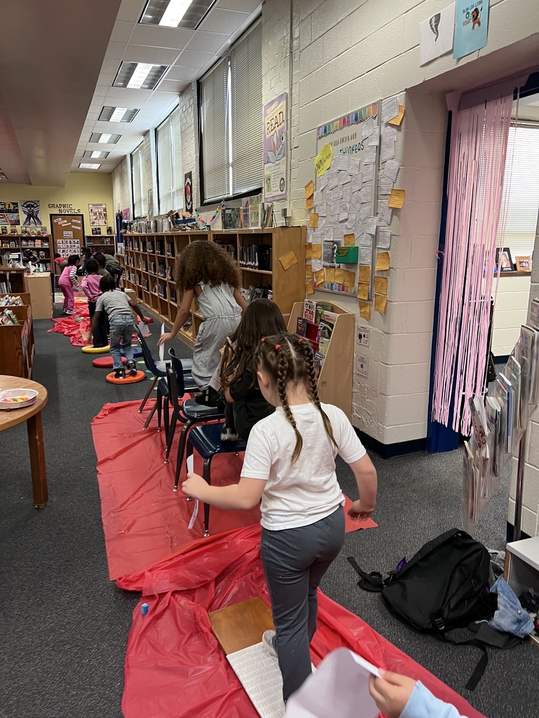 Kindergarten students walk on the red path.