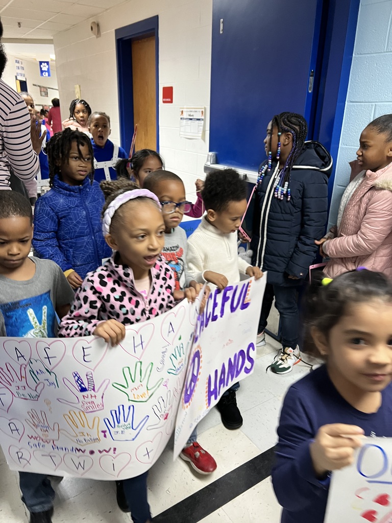 Kindergarten and 1st grade students carry their posters in the parade.