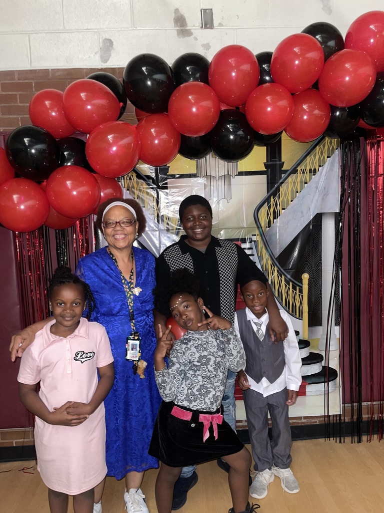 One teacher hugs a 5th grade student and 3 first graders.