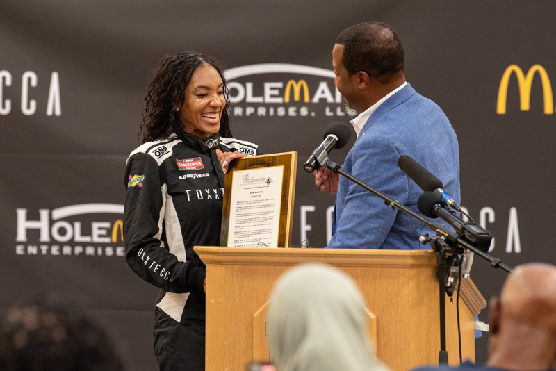 Dystany Spurlock is presented with a proclamation by Henrico Supervisor Tyrone Nelson.