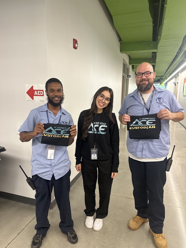 graphics student presents custom shirts to our custodians
