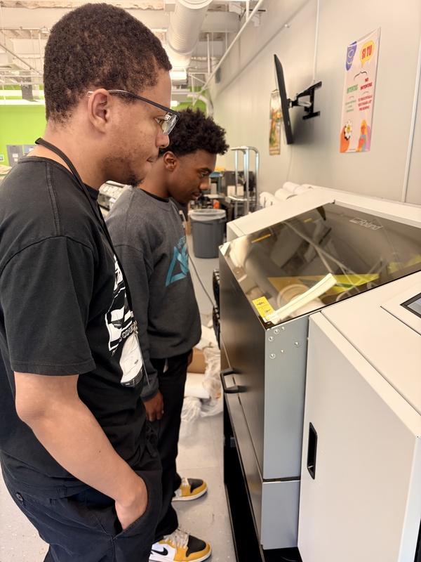 graphics studetns watch their yard sign printing
