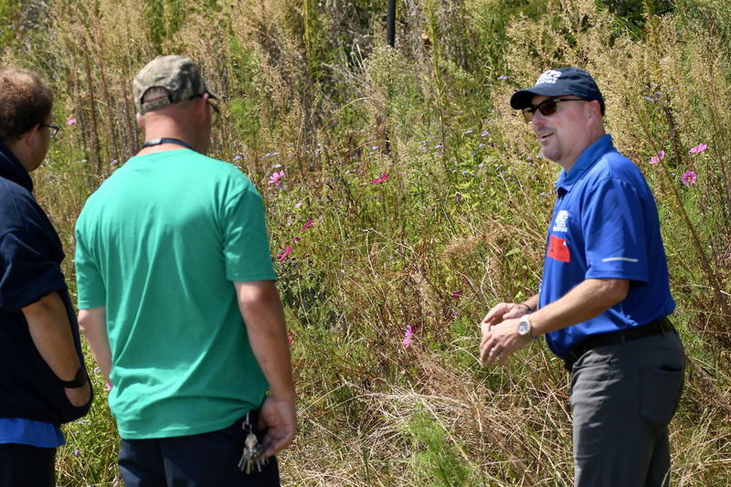 Jeff Grow, maintenance control supervisor in Henrico County Public Schools’ Facilities Department, talks with new HCPS employees. Landscaping crew members learn about the pollinator habitat at J.R. Tucker High School as part of their training.  