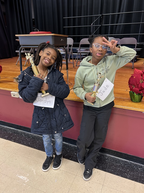 the spelling bee winner and runner up are pictured, holding their trophy