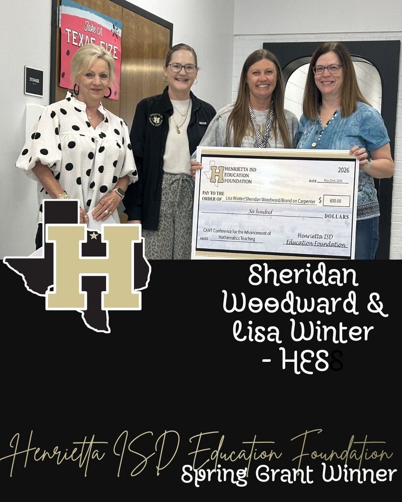 Four women pose with a check, two holding it in front of them. One wears a polka-dot shirt, another a black jacket, and the others wear blue.