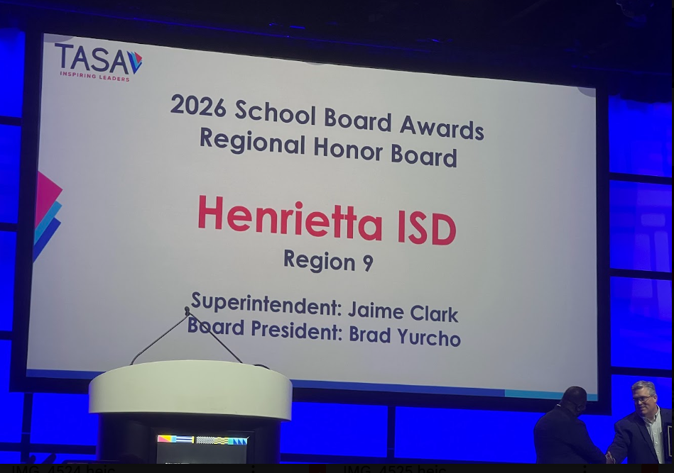 A large screen displays the 2026 School Board Awards Regional Honor Board, with Henrietta ISD highlighted. Names of Superintendent Jaime Clark and Board President Brad Yurcho appear below.