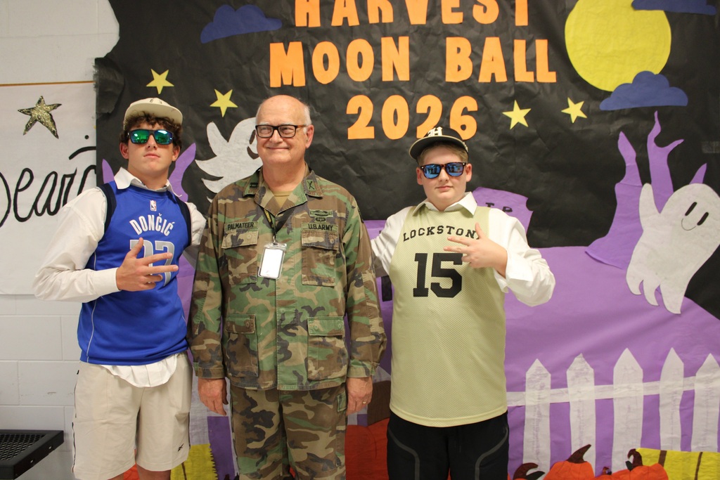 Three individuals in costume stand behind a backdrop reading Harvest Moon Ball 2026.