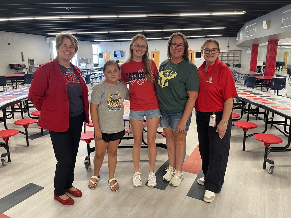 women and children posing for picture in cafeteria