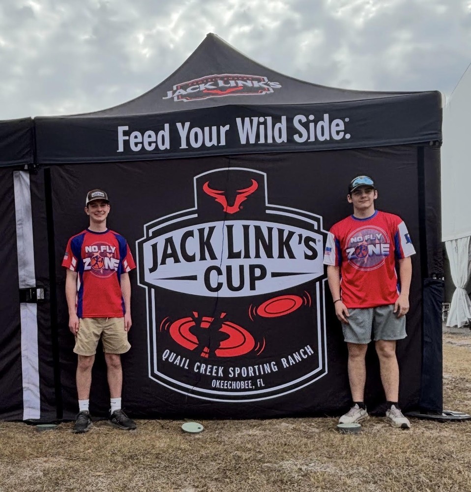 two males standing by Jack Link's cup tent