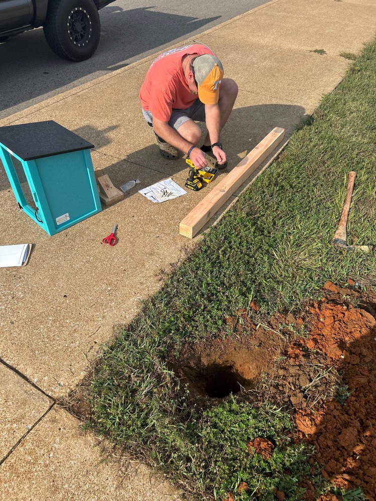 man building a little free library box