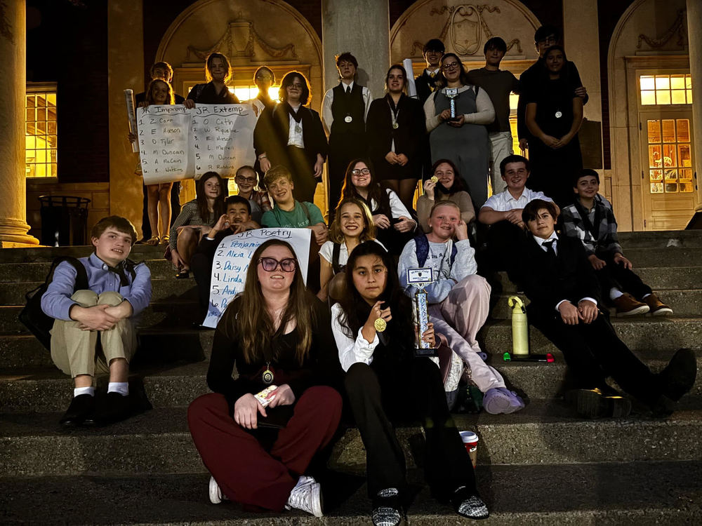 group of students on stairs holding posters