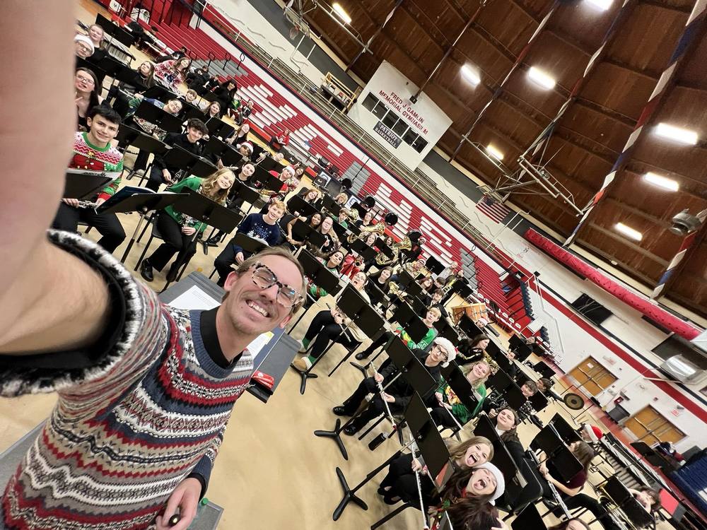 band director with student orchestra in high school gym