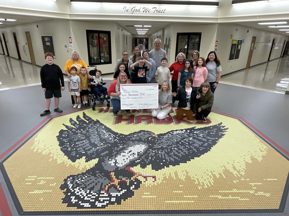 big check presented to teacher and kids