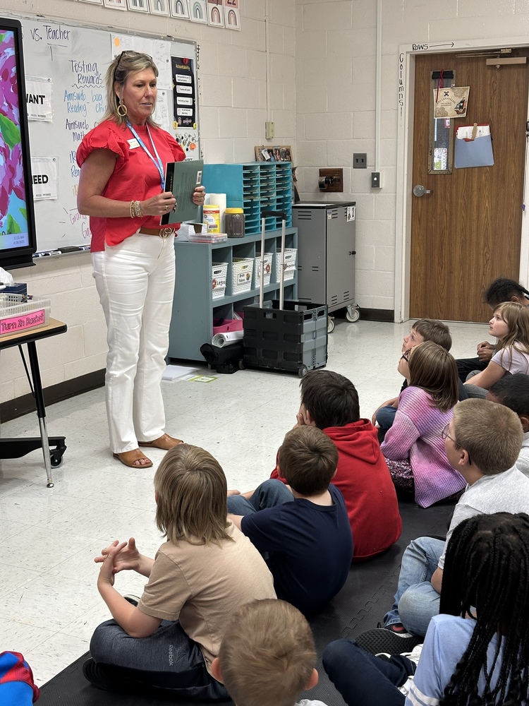 woman teaching in front of small children
