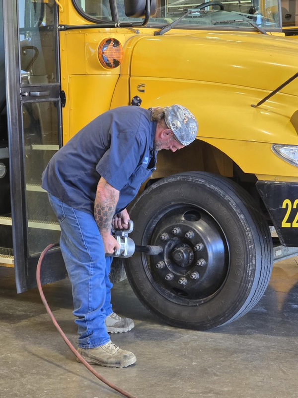 bus technician fixing tire