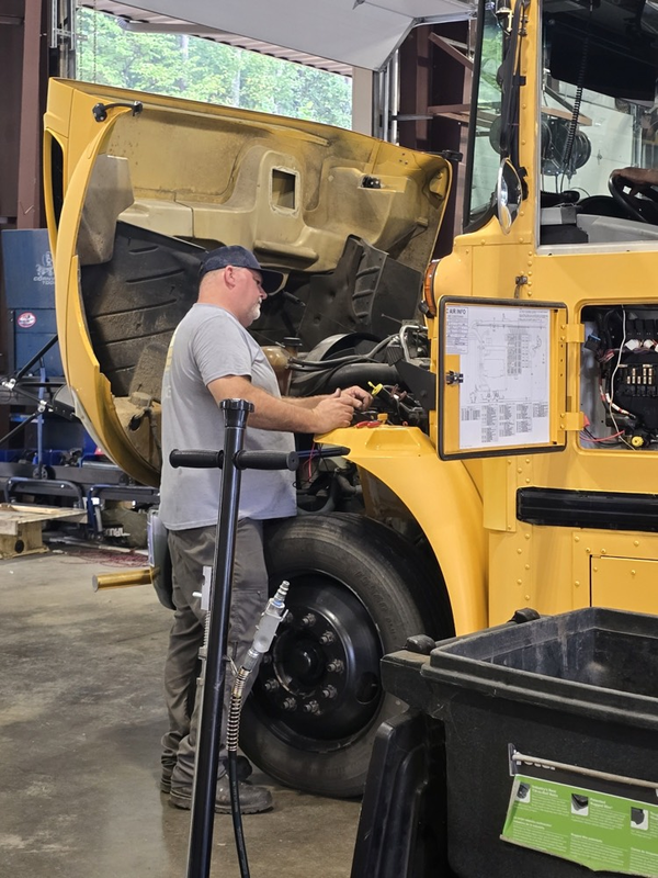 bus technician looking at engine
