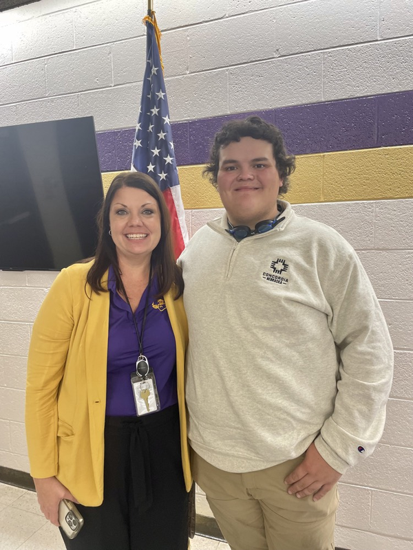 principal and student standing by flag