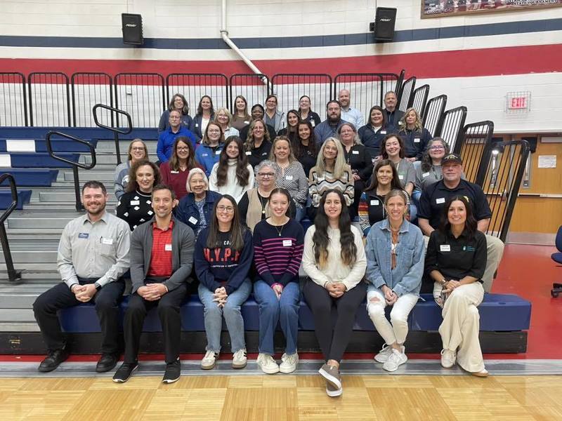 group of adults sitting on bleachers