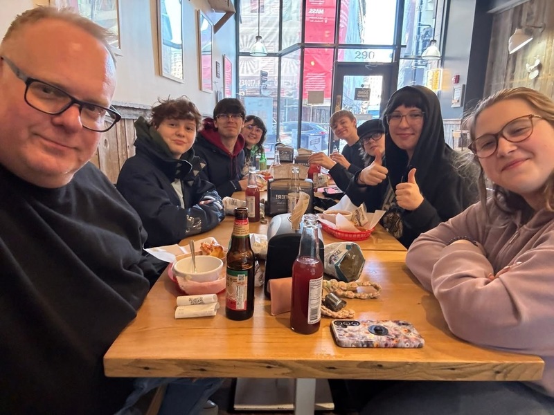 group of students with adult sitting at restaurant table
