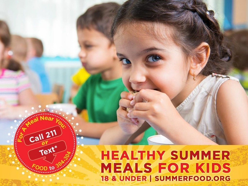 A child bites into food. Behind, children sit at a table. Text reads "Healthy Summer Meals for Kids" and "Call 211 or Text FOOD to 385-303."