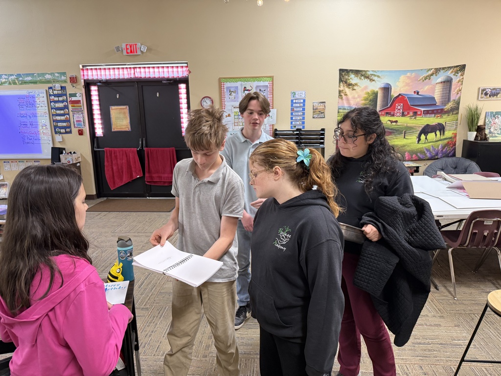 Elementary students look at a notebook