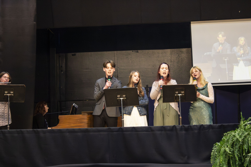 group of people singing on stage