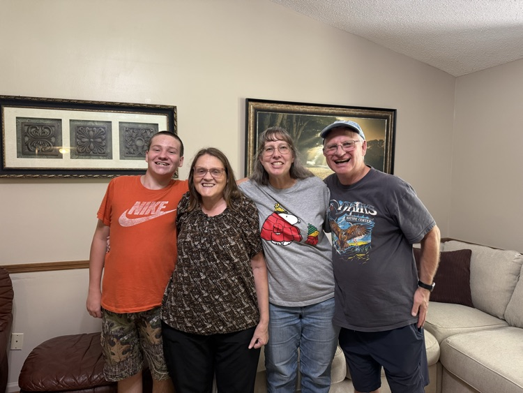 family of four posing inside a living room 