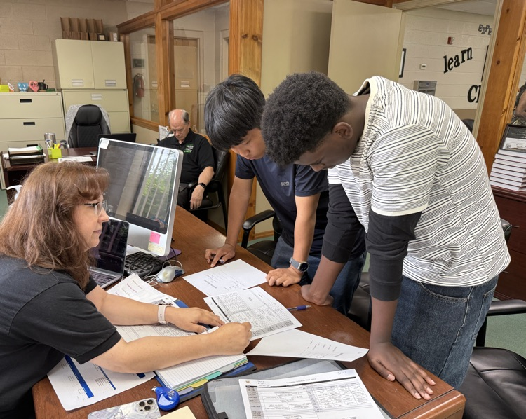 registrar with 2 students at a desk