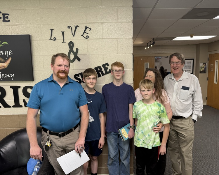 family posing inside school lobby
